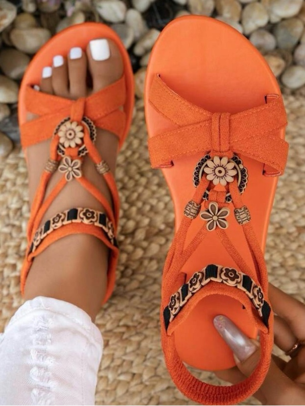 Orange Bohemian style flat sandals feature floral bead embellishments